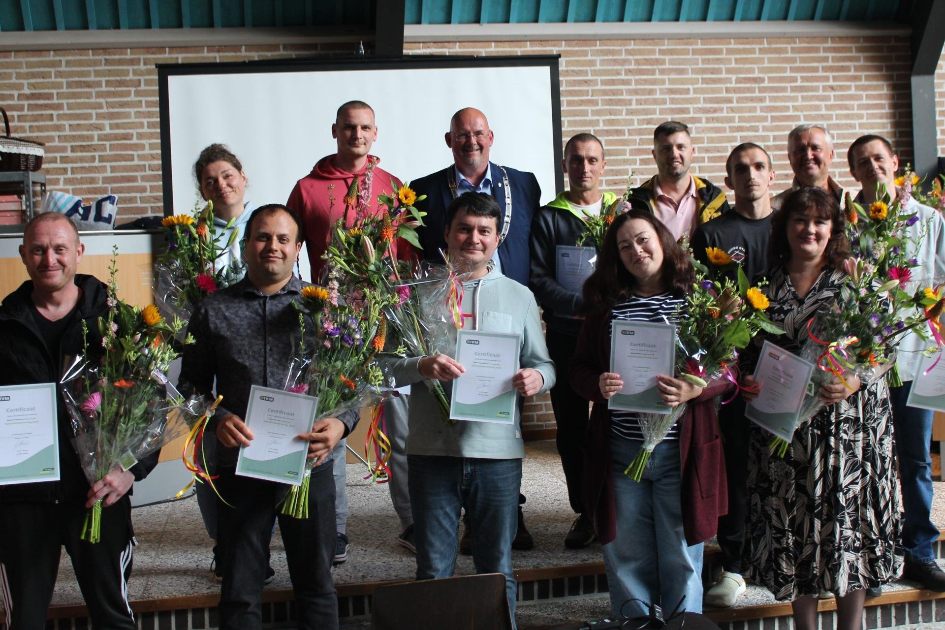 De twaalf Oekraïners samen met locoburgemeester Joop Slomp op de foto met hun zojuist ontvangen BHV-certificaat.